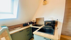 A compact kitchen with a sink, microwave, and a small countertop.
