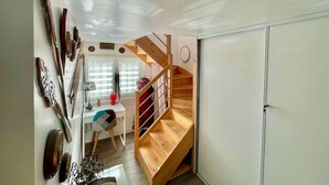 A compact room with a wooden staircase, a desk, and a wardrobe. - Les Pieds Dans L'eau (Valras-Plage)