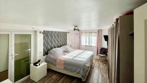 A bedroom with a bed, a nightstand, a wardrobe, and a desk with a chair. - Les Pieds Dans L'eau (Valras-Plage)