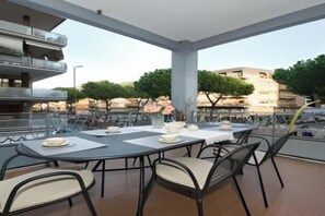 An outdoor dining area with tables and chairs, a view of the cityscape, and a building with balconies. - Modern Elegance in the Heart of Rome: Spacious 250 m² Apartment
 (Roma)