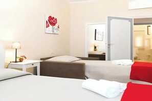A hotel room with a bed, a desk, a chair, and a red accent wall. - Modern Elegance in the Heart of Rome: Spacious 250 m² Apartment
 (Roma)
