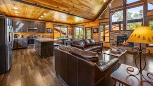 A spacious living area with a fireplace, leather sofas, and a dining table.