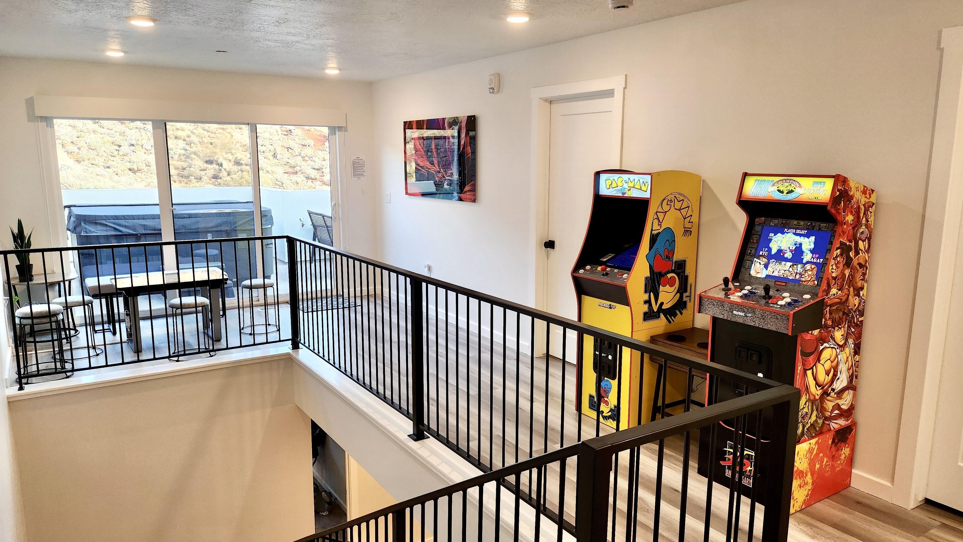 A multi-level interior with a balcony, arcade games, and a dining area.