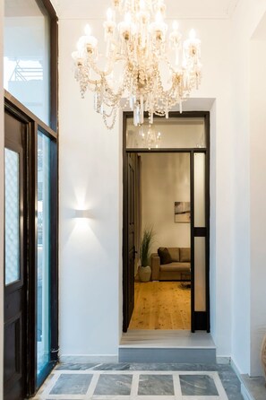 A modern interior with a chandelier, a sofa, and a wooden floor. - Aigli Seafront Loft-bespoke Design Gem (Kalamata)