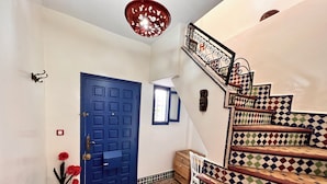 A staircase with patterned tiles, a blue door, and a red light fixture. - Charming Riad la perle des Oudayas - Rabat (Rabat)