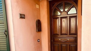 A wooden door with a glass window above it, a mailbox, and a small plaque on the wall.