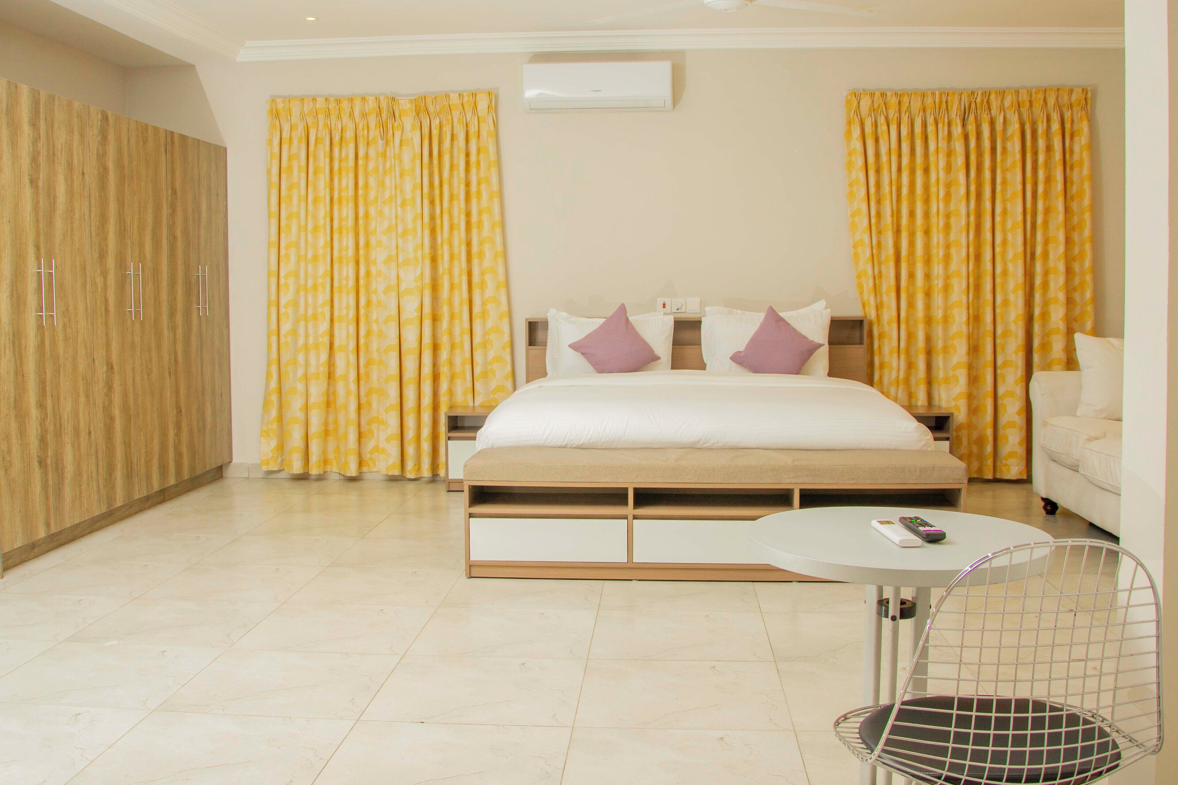 A bedroom with a bed, a bedside table, a chair, and a wardrobe.