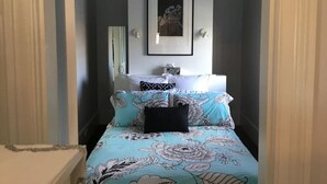 A bedroom with a bed, a chandelier, a framed picture on the wall, and a bedside table. - Cosy Studio, "The Maid" easy walking to City (Sandy Bay)