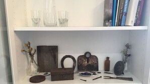 A shelf with various items including books, a vase with dried flowers, and a rustic wooden box. - Cosy Studio, "The Maid" easy walking to City (Sandy Bay)