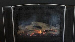 A fireplace with a fire burning inside. - Cosy Studio, "The Maid" easy walking to City (Sandy Bay)