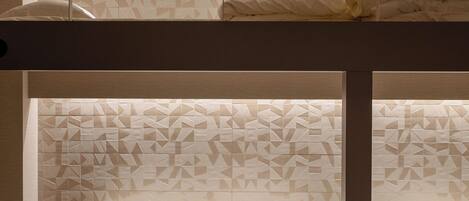 A bunk bed room with a geometric patterned headboard and a ceiling light fixture.