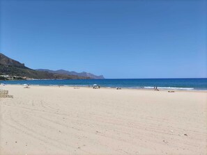 A wide sandy beach with a clear blue sky and calm sea. - Case Vacanze Sicania nel Centro Storico di Castellammare del Golfo (Castellammare del Golfo)