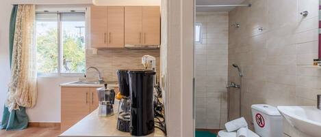 Una cocina moderna con horno integrado, cafetera y fregadero.