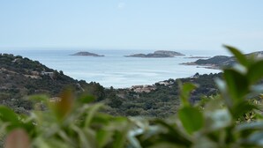 Un paysage côtier offrant une vue sur la mer et sur des îles lointaines.