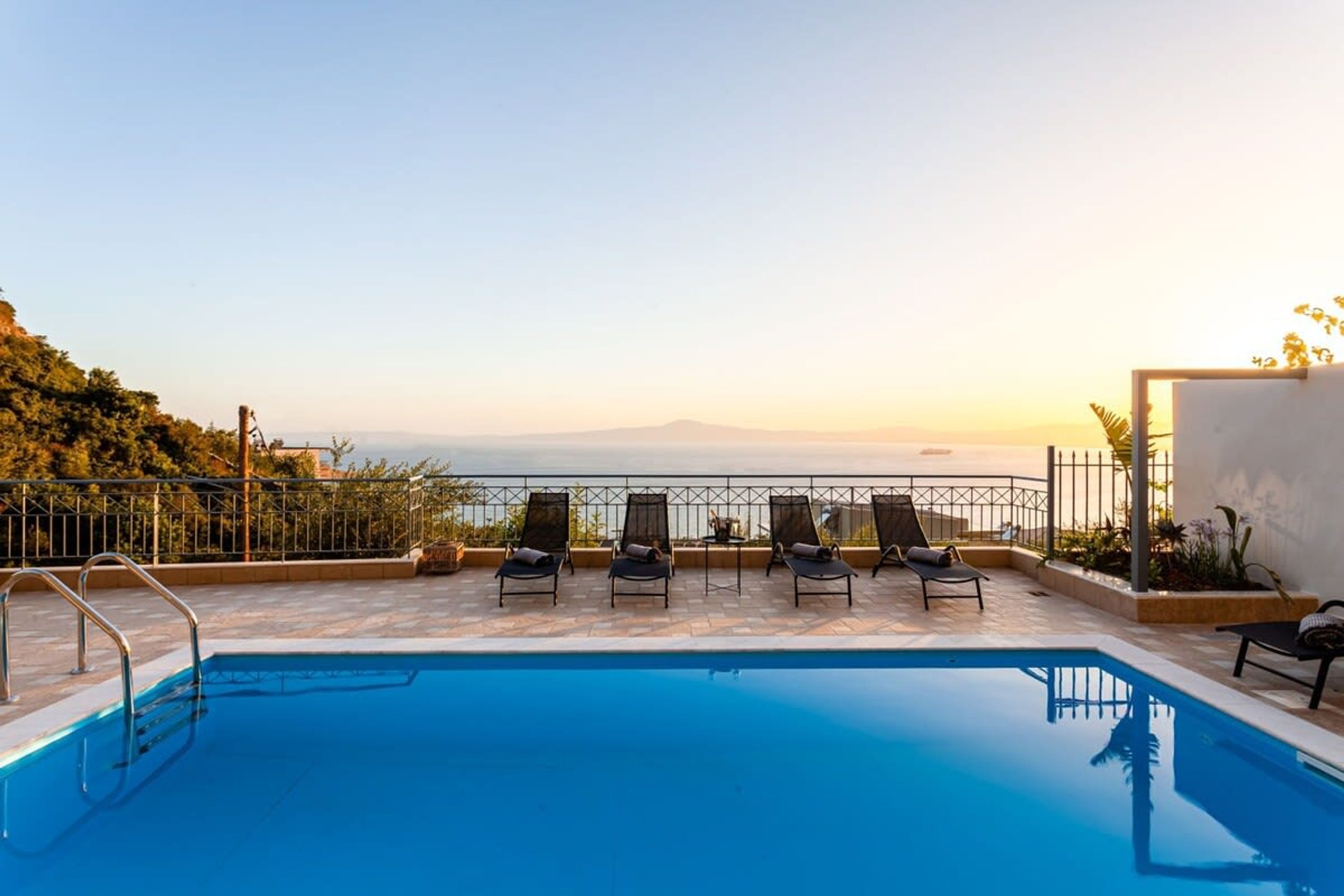 Una piscina con sillas de descanso y vistas al mar.