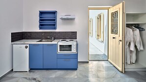 A compact kitchen with blue cabinets, a white refrigerator, and a stove. - Villa Maria - Naoussa Fishes Blue Grey Suite (Paros)