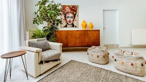 Ein Wohnzimmer mit einer Couch, einem Couchtisch, einem Schrank und zwei Poufs.