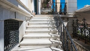 A staircase leading to a building entrance with a wooden ceiling and a metal railing. - Aigli Seafront Loft-luxury Design Retreat (Kalamata)
