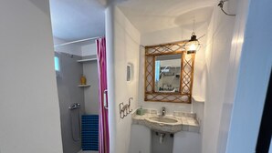 A bathroom with a shower, a sink, and a mirror. - Mykonos Violet Nest - Sea View Escape (Mykonos)
