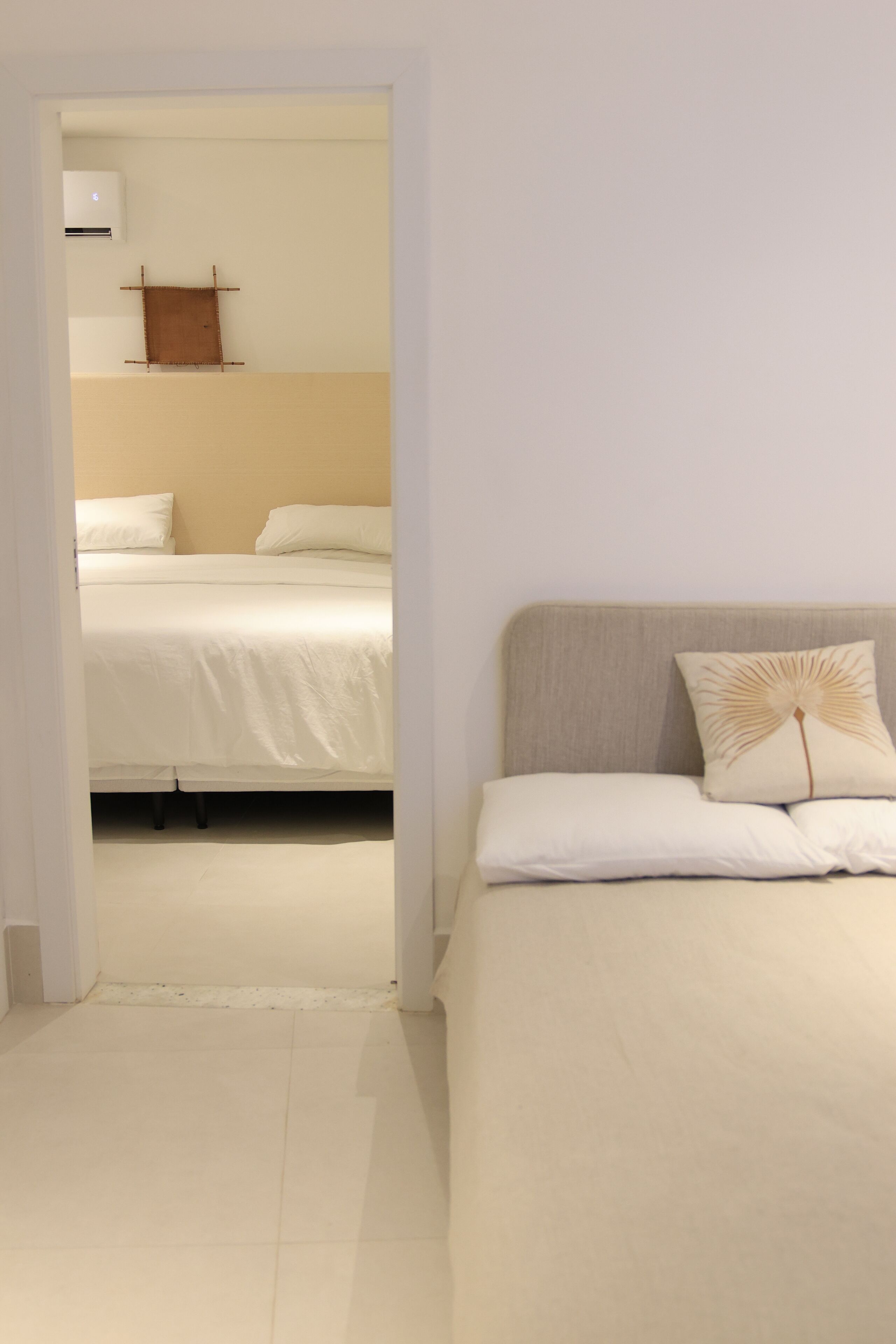 Un dormitorio con cama, mesita de noche y aire acondicionado de pared.