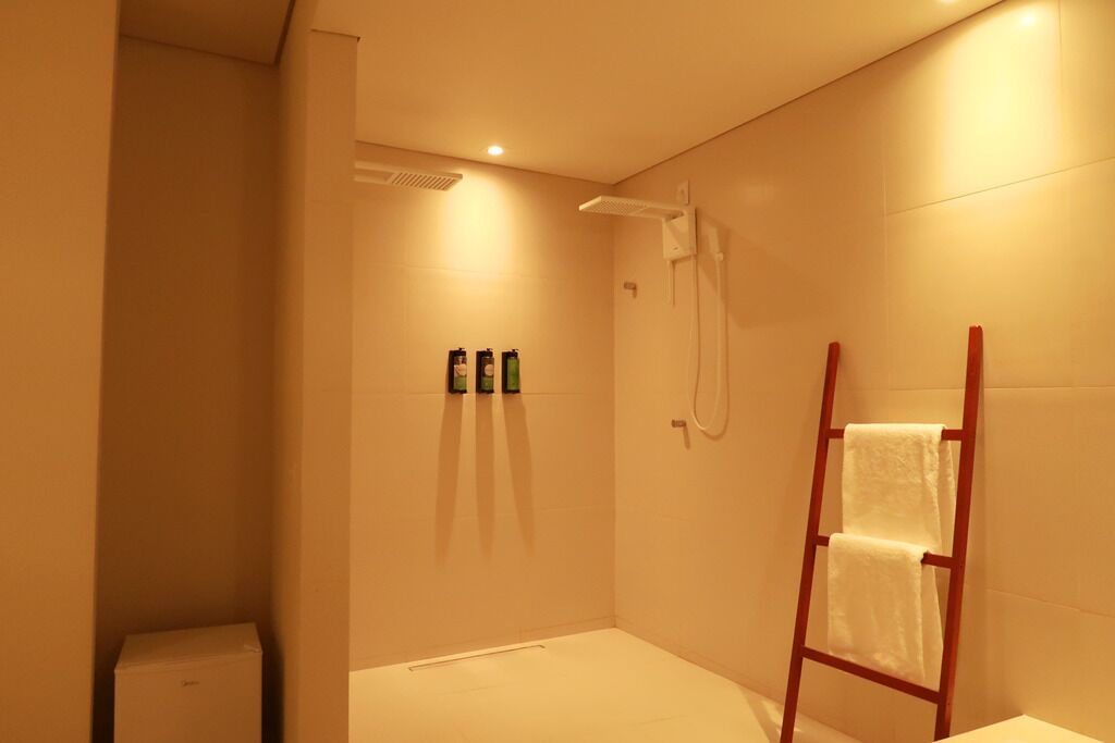 Un baño pequeño y moderno con ducha, inodoro y barra para toallas.
