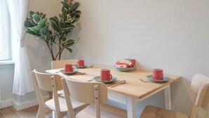 A dining area with a wooden table, four chairs, and a potted plant. - Cosy & quiet apartment w/great transport links (Erfurt)