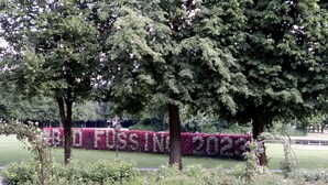 Un parque con una banca, árboles y un seto que deletrea 'FUSSI 2023'.