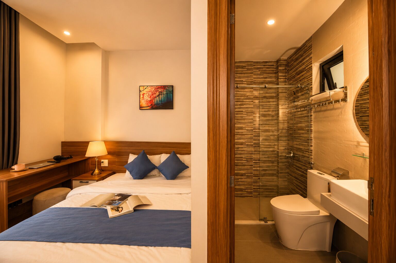 A hotel room with a bed, bedside table, lamp, and a painting on the wall.
