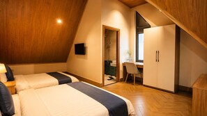 Une chambre avec deux lits, un bureau et une armoire.