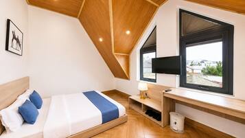 A modern bedroom with a bed, a desk, a TV, and a window with a view.