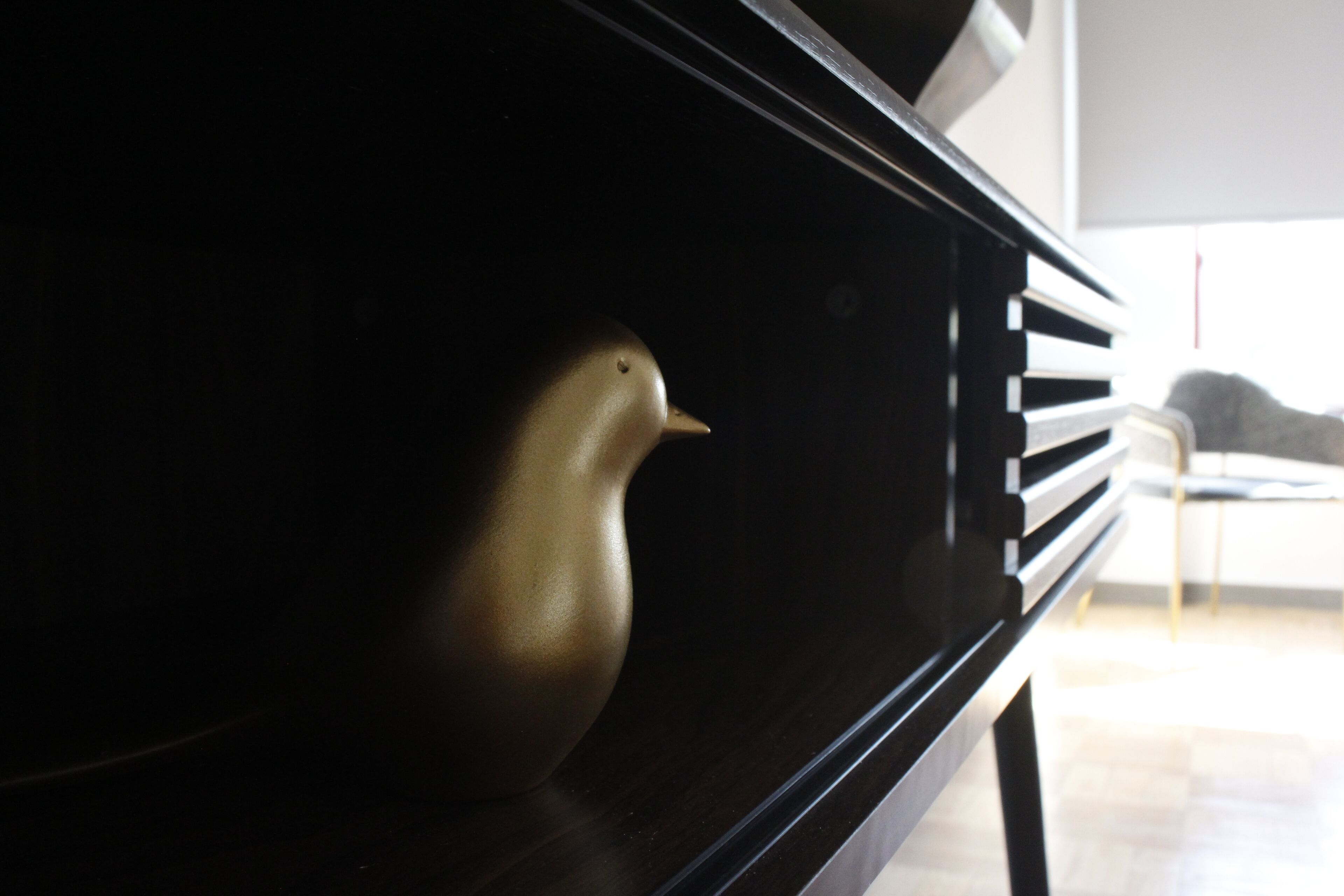 A close-up of a piano with a bird figurine on it.