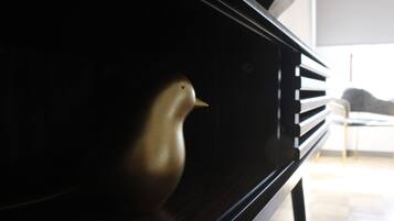 A close-up of a piano with a bird figurine on it.