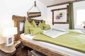 Relax in this serene bedroom with a comfortable bed, framed artwork, and a cozy reading nook.