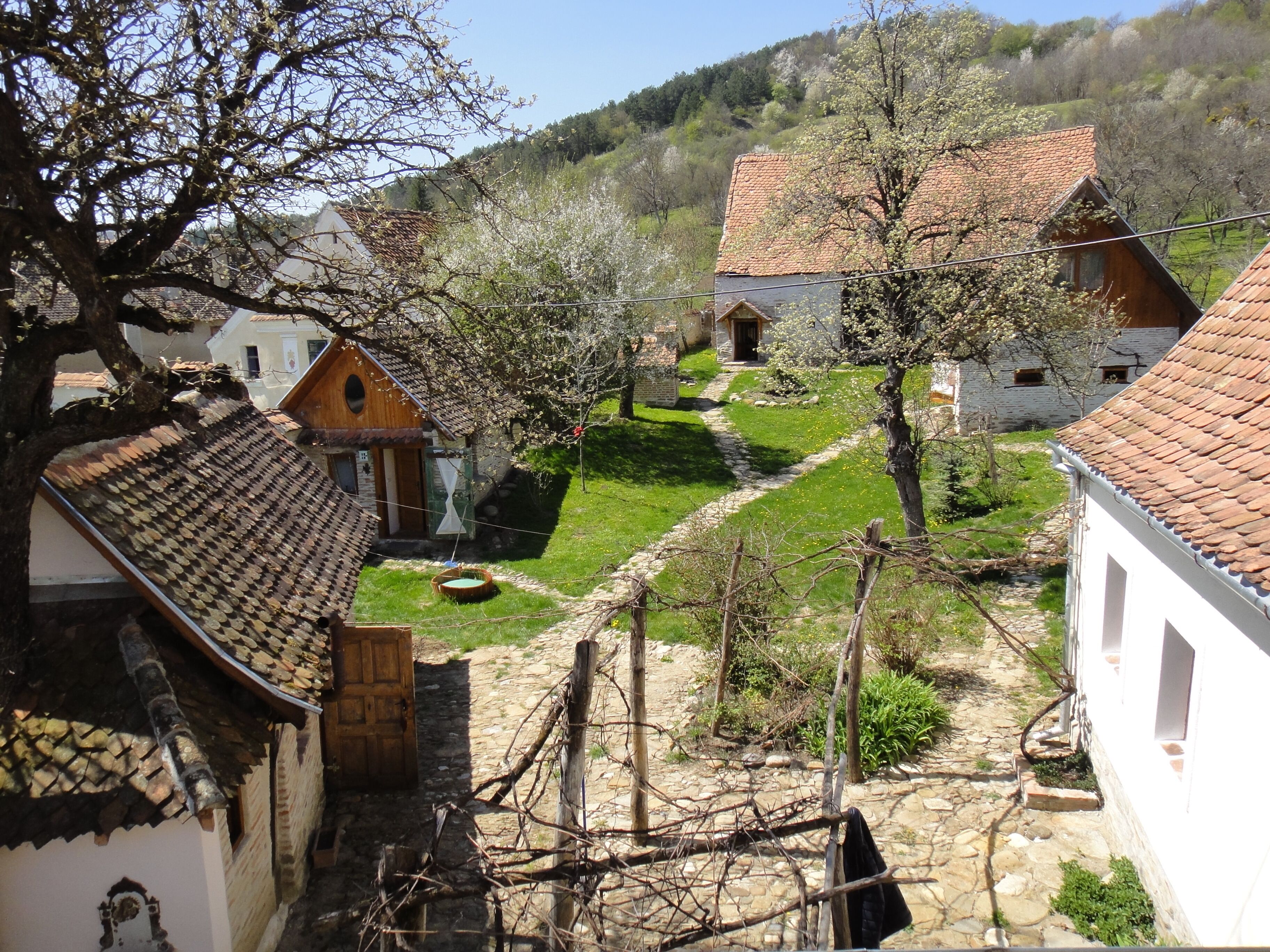 Un pueblo tradicional con casas de piedra, un camino de piedra y un pequeño estanque.
