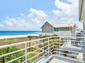 Ein Hotel direkt am Strand mit einem Balkon mit Blick auf den Ozean.