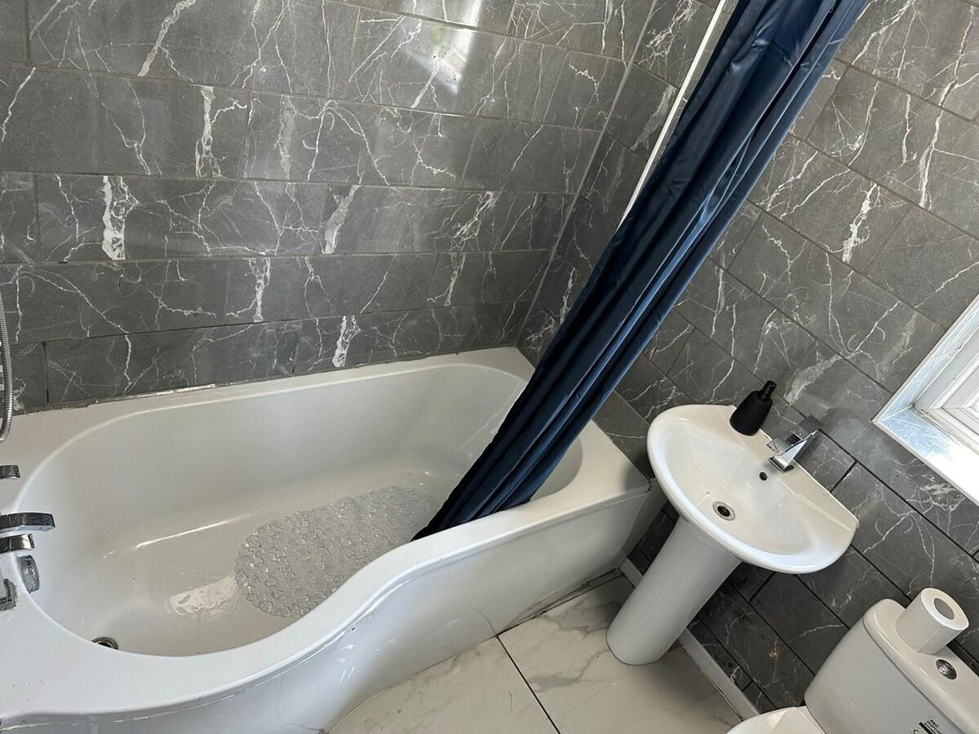 Une salle de bain avec une baignoire, un lavabo et des toilettes.