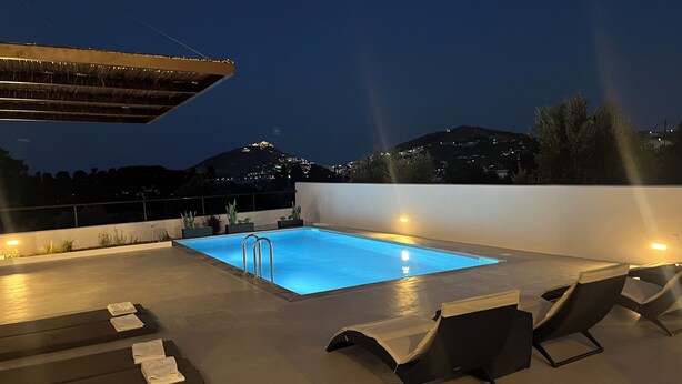 A rooftop pool with a view of a cityscape at night. - Serenity Bay, Cycladic Villa with Pool and magnificent view near the beach. (Leros)