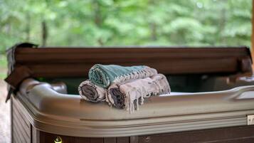 A hot tub with rolled towels and a control panel.