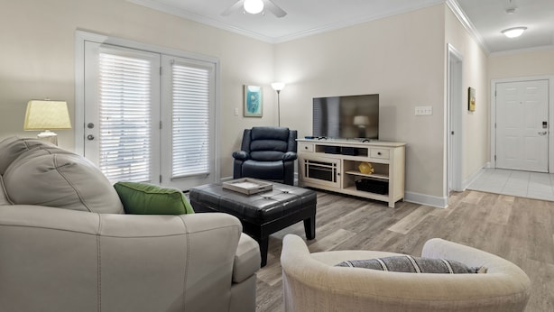 A living room with a sofa, armchair, ottoman, TV stand, and ceiling fan. - Fabulous Foley near the beach, ball fields, & OWA (Foley)