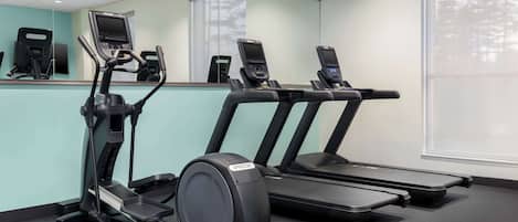 A fitness room with treadmills and an elliptical machine.