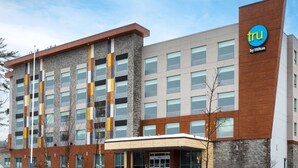 A modern hotel building with a mix of brick and wood facade, multiple windows, and a prominent 'tru by Hilton' sign. - Tru By Hilton Bracebridge, On (Bracebridge)