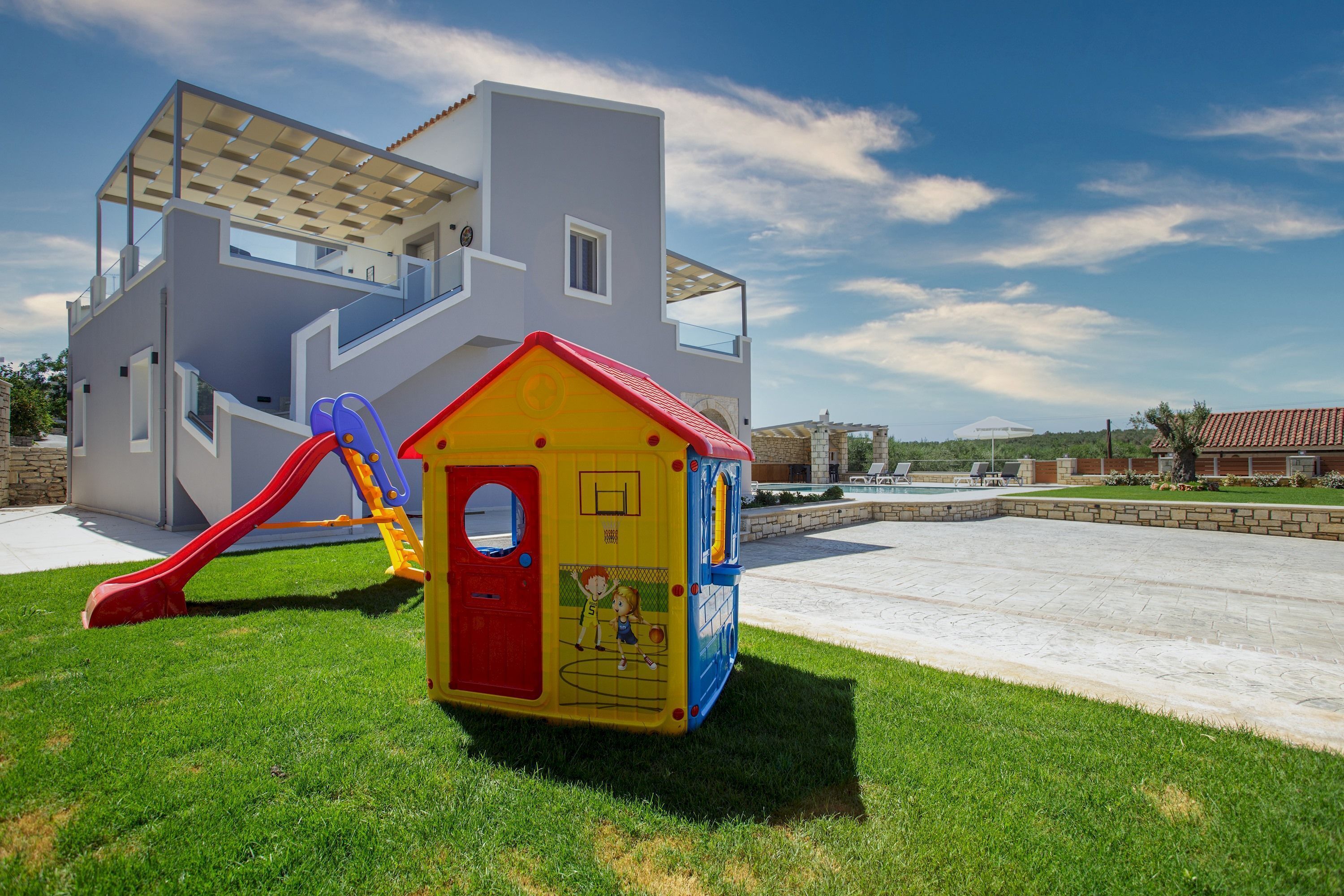 Une maison moderne avec une maison de jeu pour enfants devant.