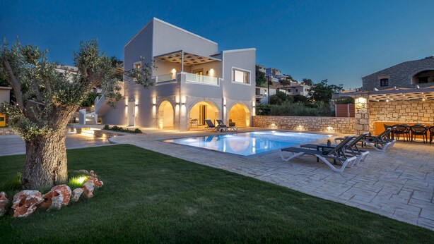 A modern two-story house with a swimming pool, outdoor seating, and a well-lit patio area. - Villa Chara by Estia (Mylopotamos)