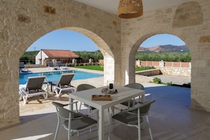 A patio area with a pool, stone arches, and outdoor seating.