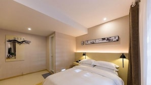 Ein Hotelzimmer mit einem Bett, Nachttischlampen, einem Spiegel und Bildern an der Wand.