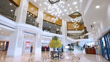 A spacious atrium with a central fountain, multiple levels, and a grand staircase.