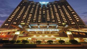 A high-rise hotel with multiple floors, a prominent entrance, and a well-lit facade.