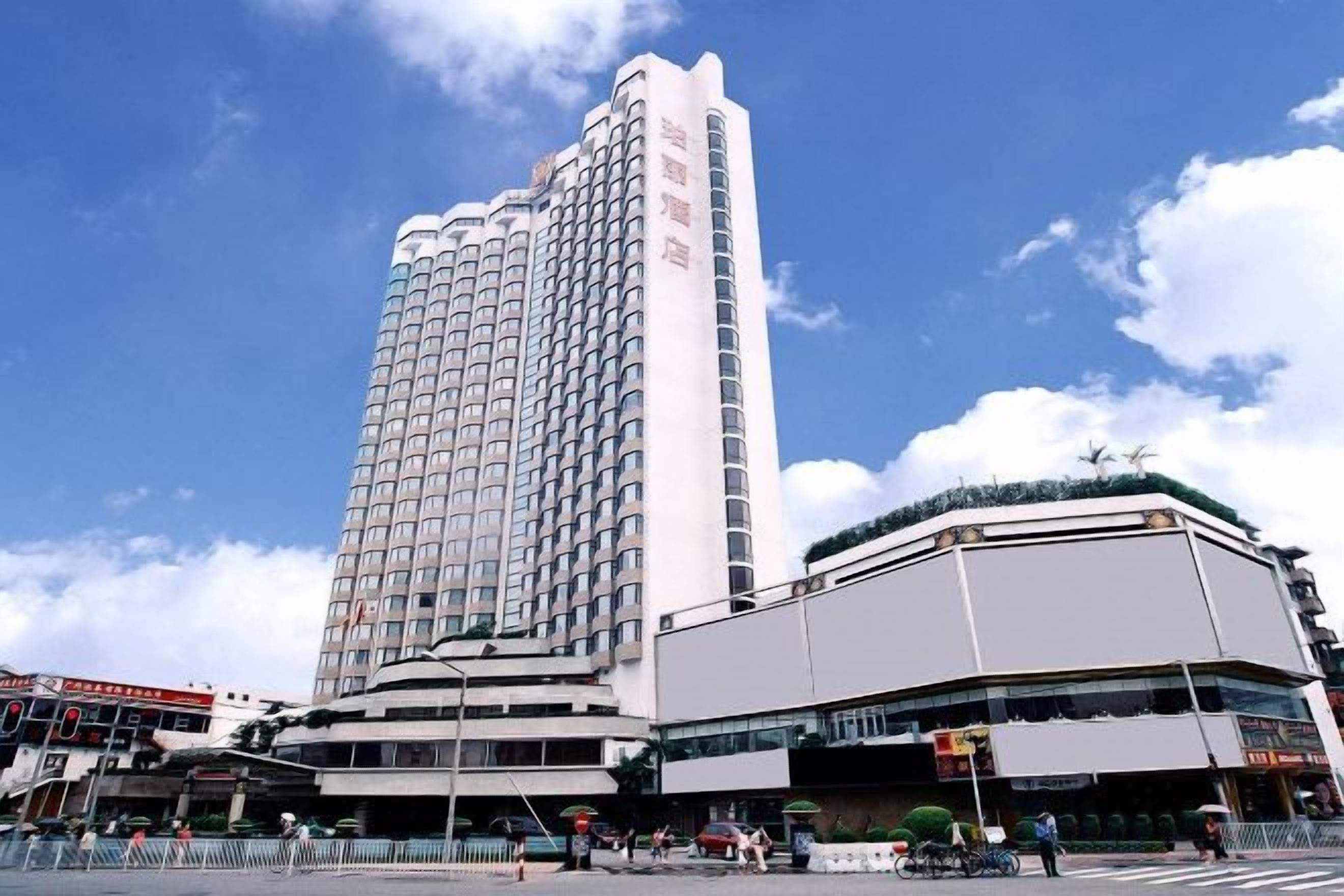 A high-rise hotel with a modern design, located at a city intersection.