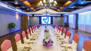 A conference room with a long table set for a formal event, a large screen displaying a heart, and a chandelier. - Taizhou Sanyou International Hotel (Shili Changjie) (Taizhou)