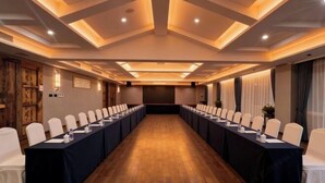 A conference room with a long table, white chairs, and a wooden floor. - Taizhou Sanyou International Hotel (Shili Changjie) (Taizhou)